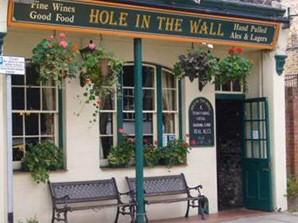 Man Drinks in Hole in Wall