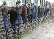 Men standing on bikes watching football