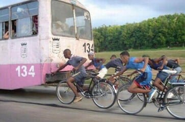 Cyclists holding on to bus