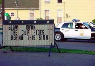 slow down cop sign