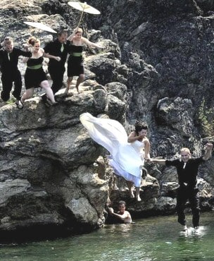 Bride and groom jumping into water