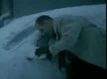 Man clears snow from car mirror