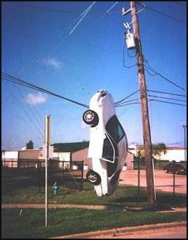 Car hanging from telegraph lines