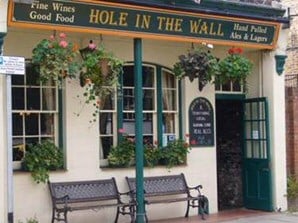 Man Drinks in Hole in Wall